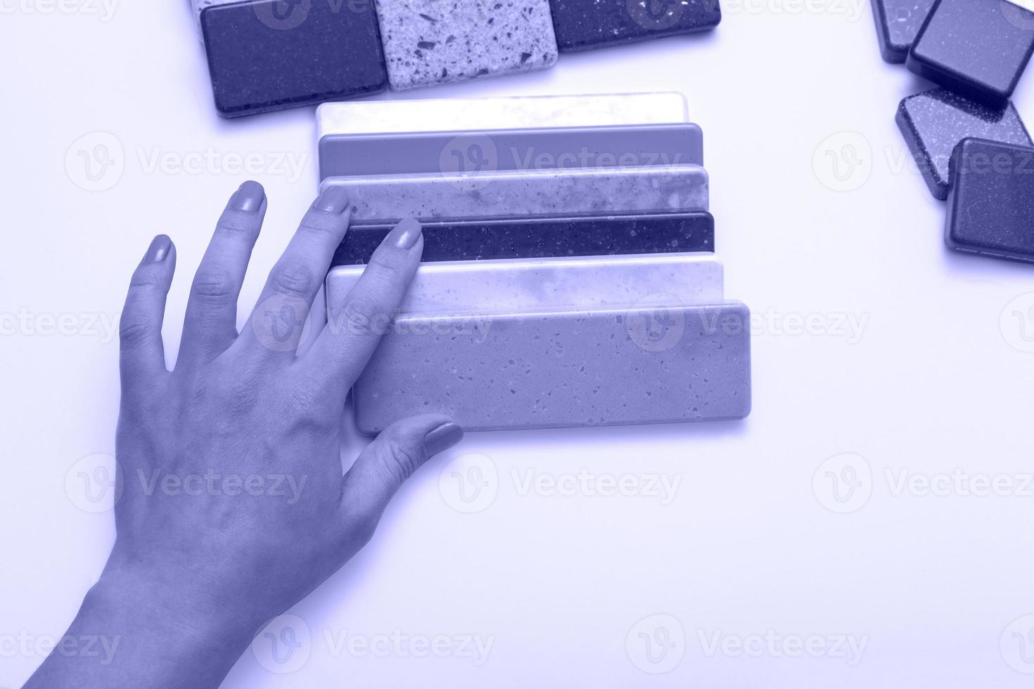 Mock up from natural stones, top view, closeup. Female hands advertises repair materials. Floor tiles, tiles, countertops. photo