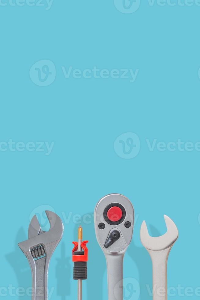 Cover page with a set of workshop tools with shadows at solid turquoise background with copy space. Concept of hardware, gears, and workshop work. photo