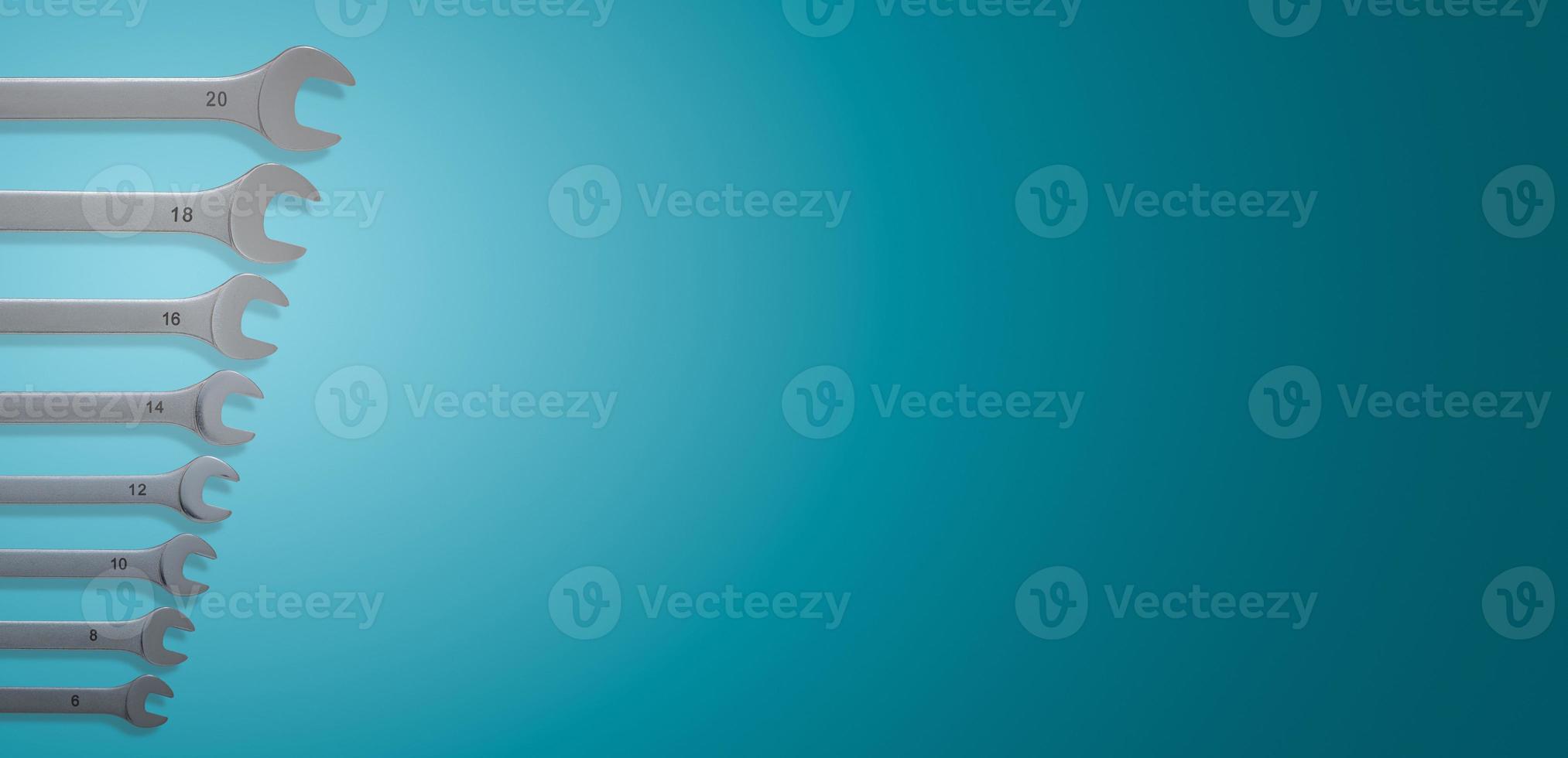 Banner with a set of workshop wrenches of different size with shadows at gradient turquoise background with copy space. Concept of hardware, gears, and workshop workflow. photo