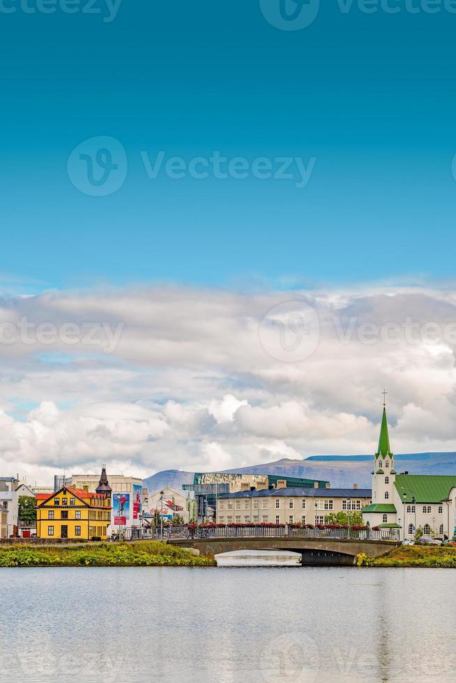 Historical and touristic downtown in Reykjavik at Summer in Iceland, cityscape at sunset at inner lake around Tjornin city park in the downtown with copy space blue sky. photo