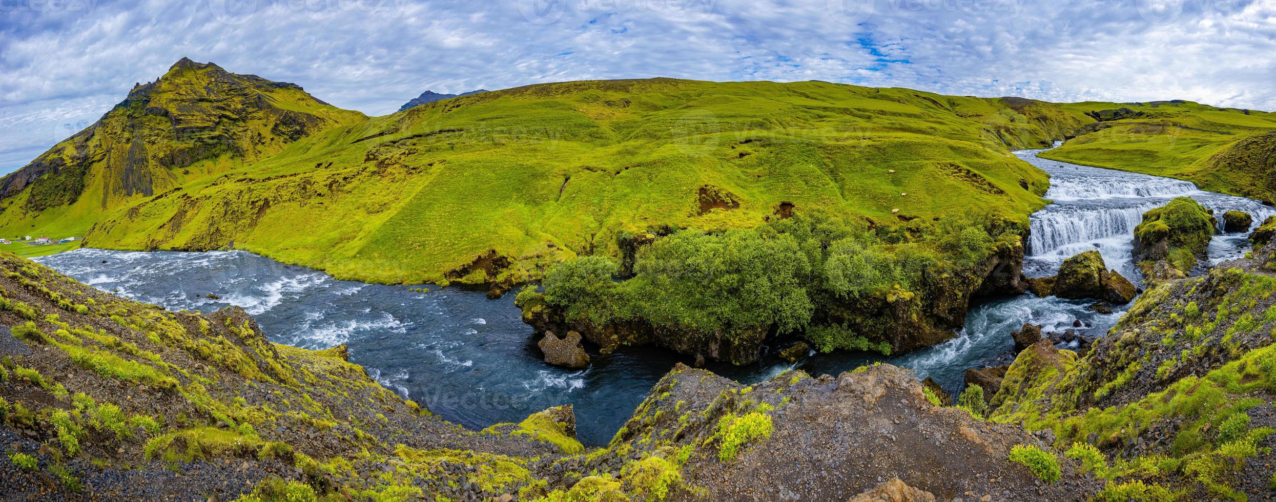 Panoramic view of cascade of small waterfalls near huge Skogafoss waterfall on South Iceland photo