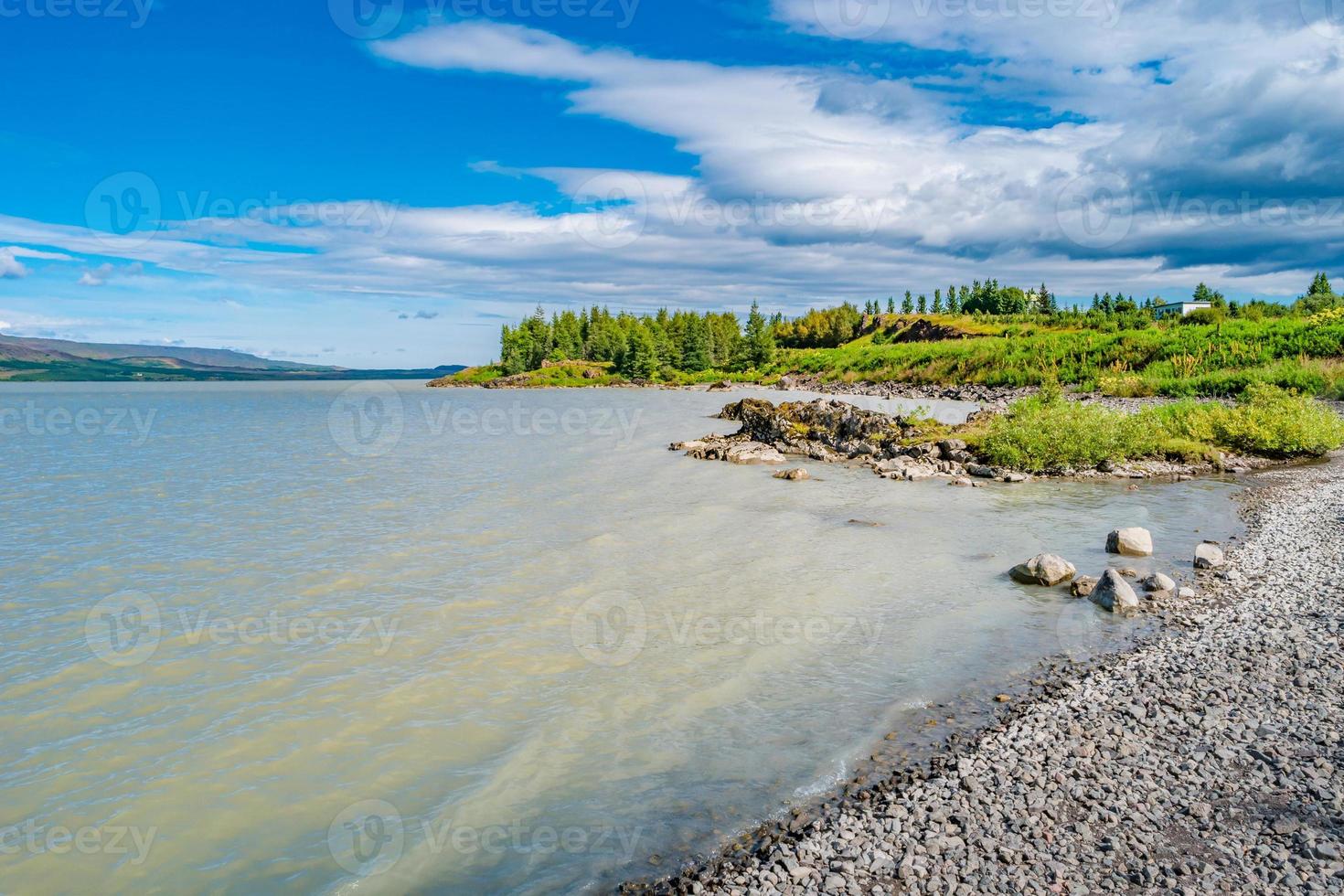 Biggest in Iceland lake called Lagarfjot at sunny day and blue cloudy sky, summer. photo