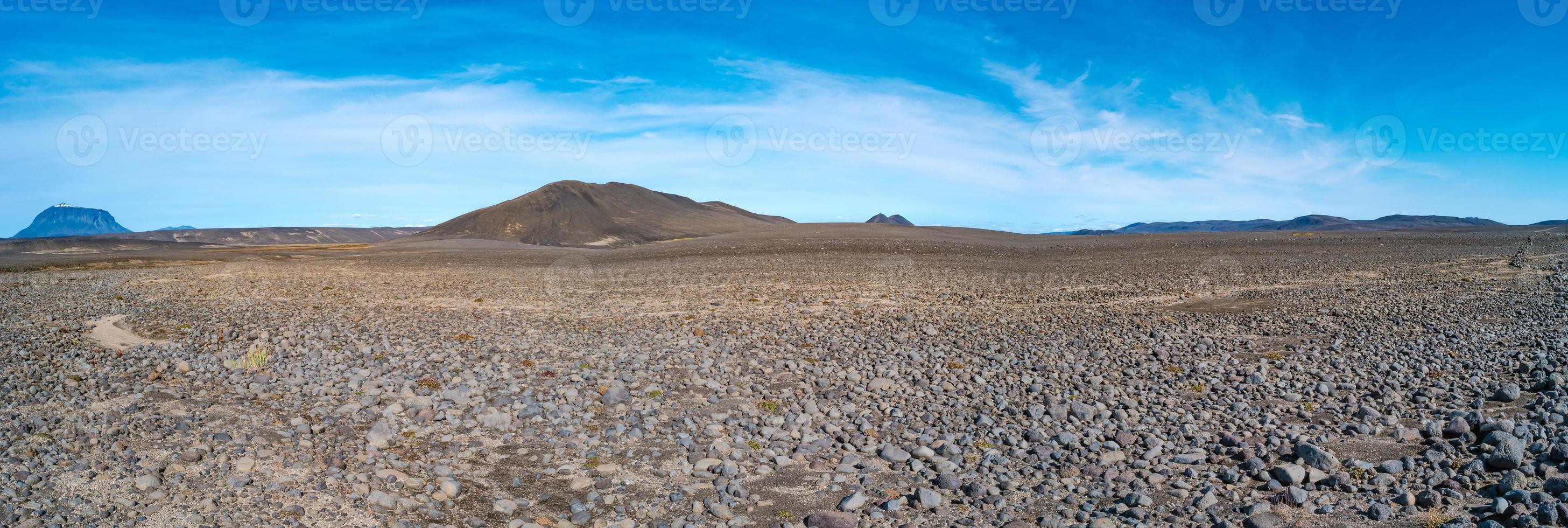 Panoramic view over Icelandic landscape of the deadliest volcanic desert in Highlands, with stones and rocks thrown by volcanic eruptions and hiking trek along the off road, Iceland, summer, blue sky. photo