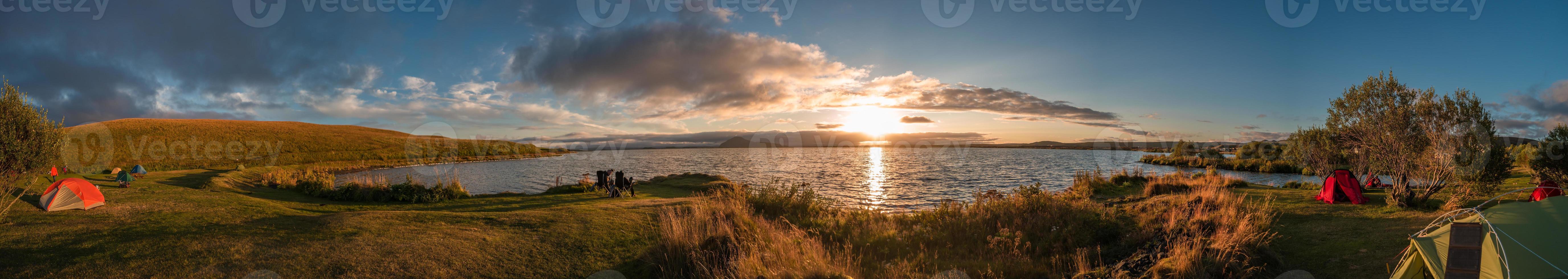 vista panorámica del lago myvatn en las tierras altas de islandia con tiendas de campaña en el camping durante la increíble puesta de sol en verano, islandia. foto
