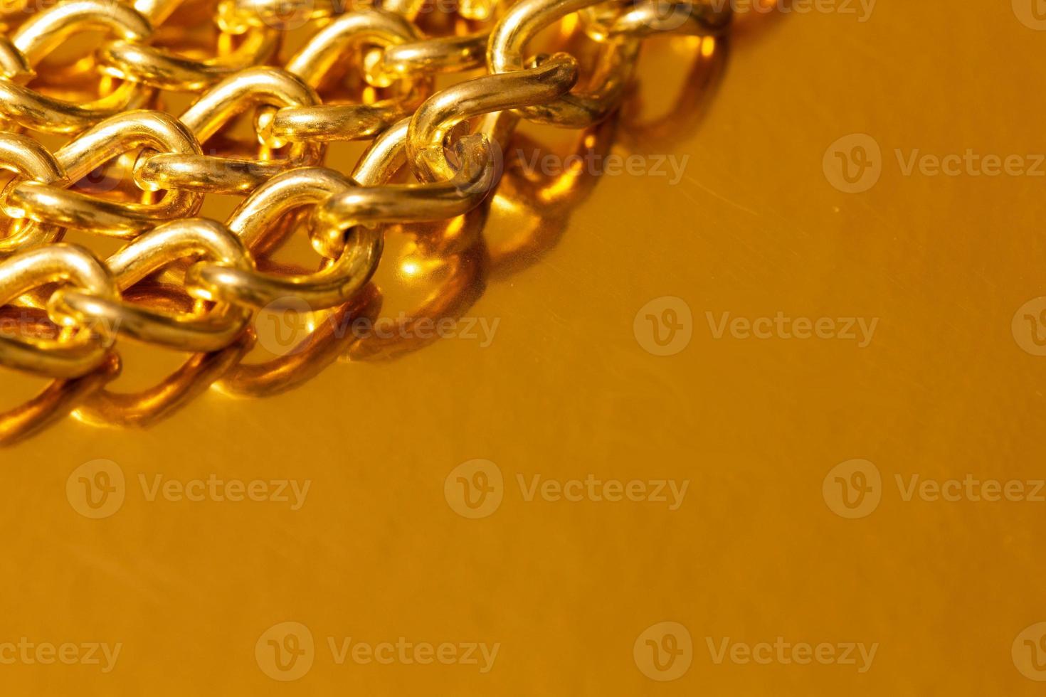Golden chain. Detail of a yellow iron chain. Metal chain link on the gold background. Decorative jewelry. Luxury design brilliant jewelry. Macro photo for ads, flyers. Copy space for text. Close-up