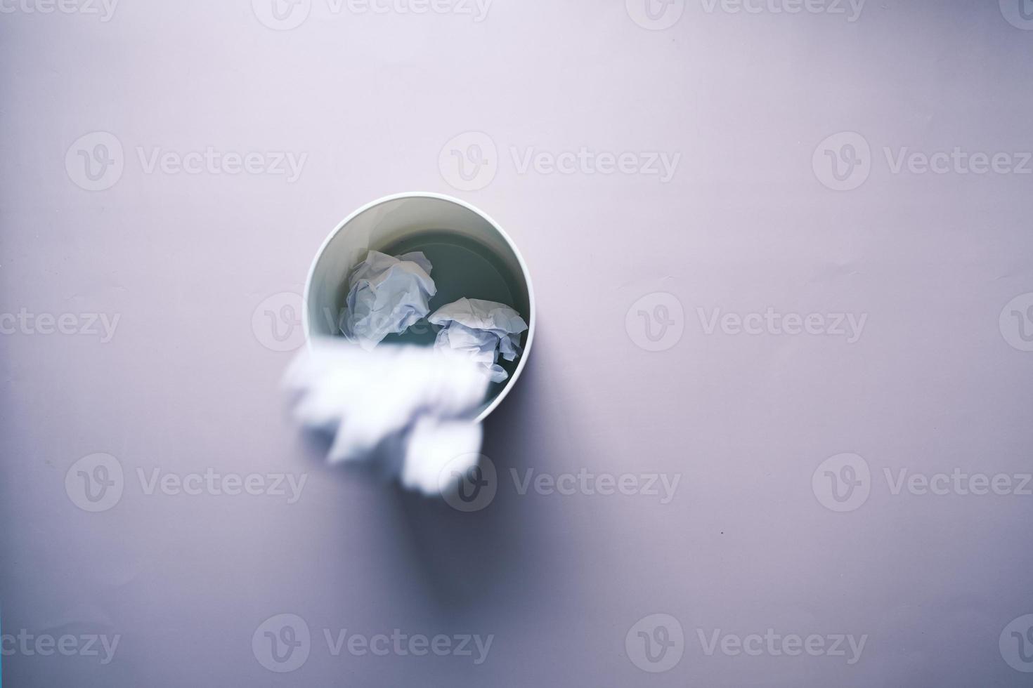 crumpled paper ball in a bin top view photo