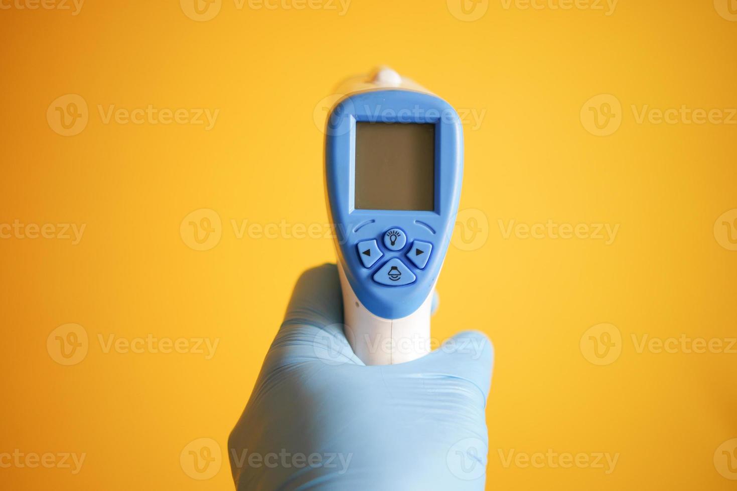 Hand holding infrared thermometer to measuring temperature. photo