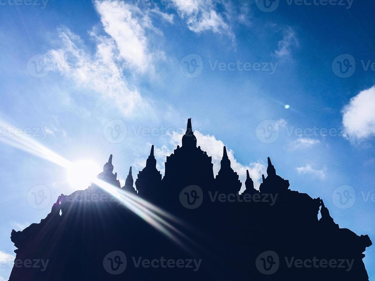 Silhouette view of Plaosan Temple in Plaosan Complex temple with blue sky and sunny sun background. One of the javanese Buddhist temples located in Prambanan, Klaten, Central Java, Indonesia. photo