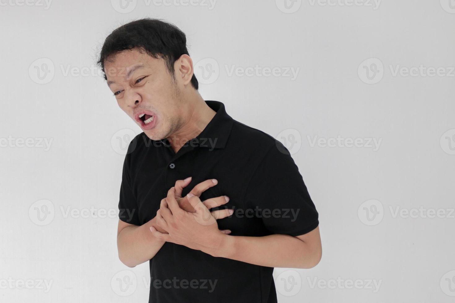 Heart attack or broken heart of young asian man with hurt emotion wear black shirt photo