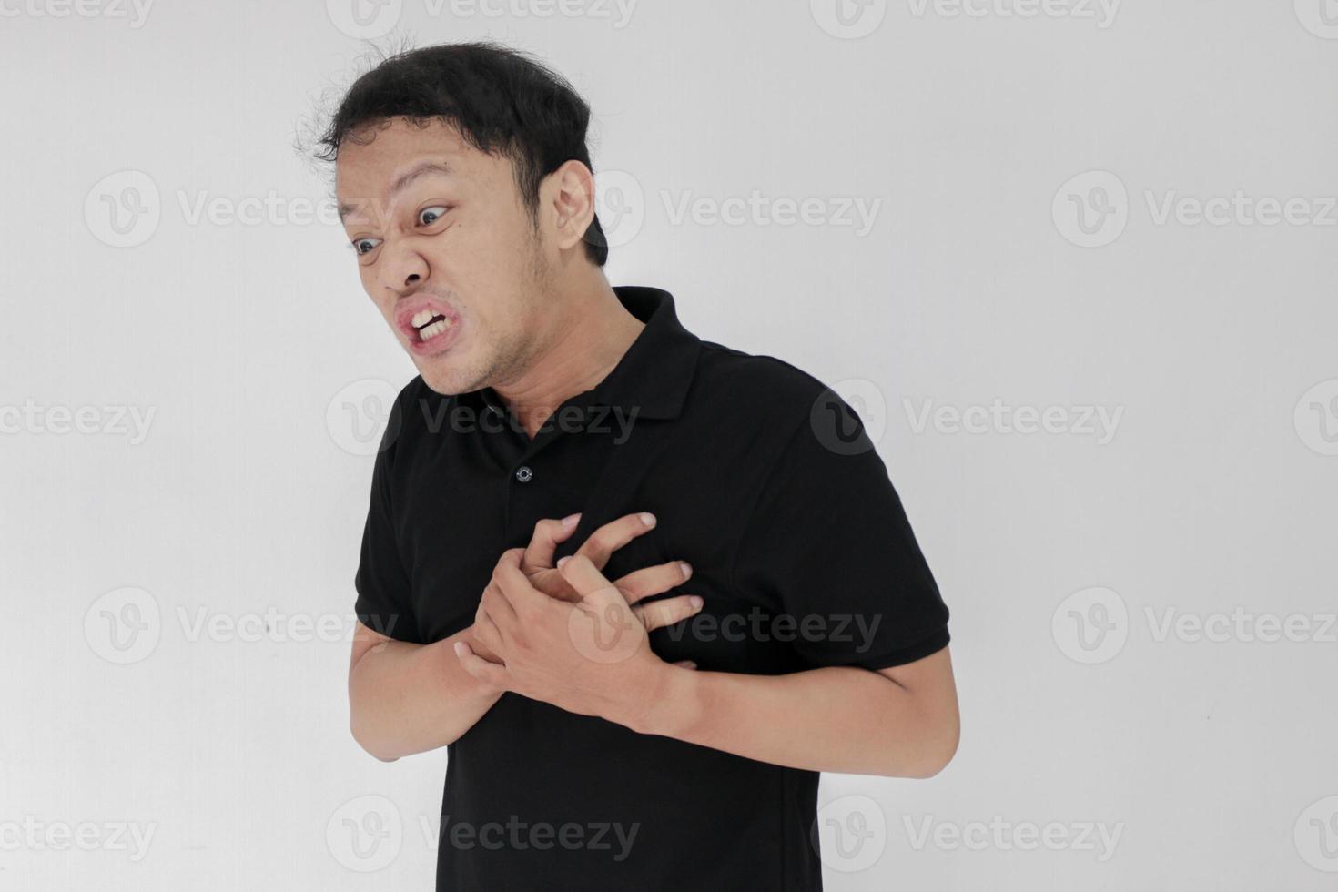 Heart attack or broken heart of young asian man with hurt emotion wear black shirt photo