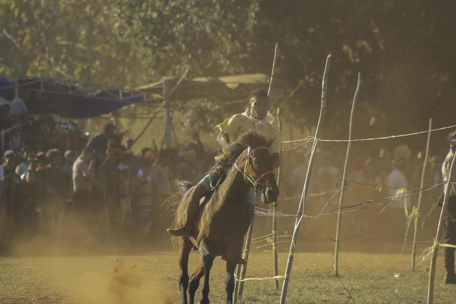 Young man jockeys in horse racers at Hus traditional horse race culture from Rote Island, East Nusa Tenggara, Indonesia. Rote, Indonesia - March 27, 2020 photo