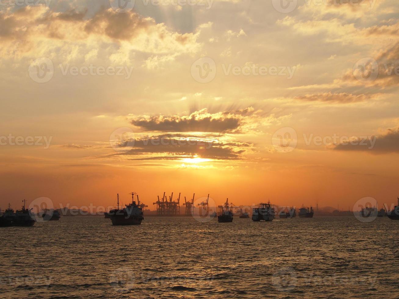 Cargo ship and cranes at port harbour in Tanjung Perak Surabaya with sunset sky background. photo