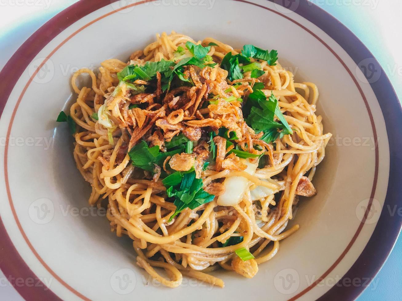 Mie Goreng Jawa or bakmi jawa or java noodle. Indonesian traditional street food noodles from central java or Yogyakarta, indonesia on white background. photo