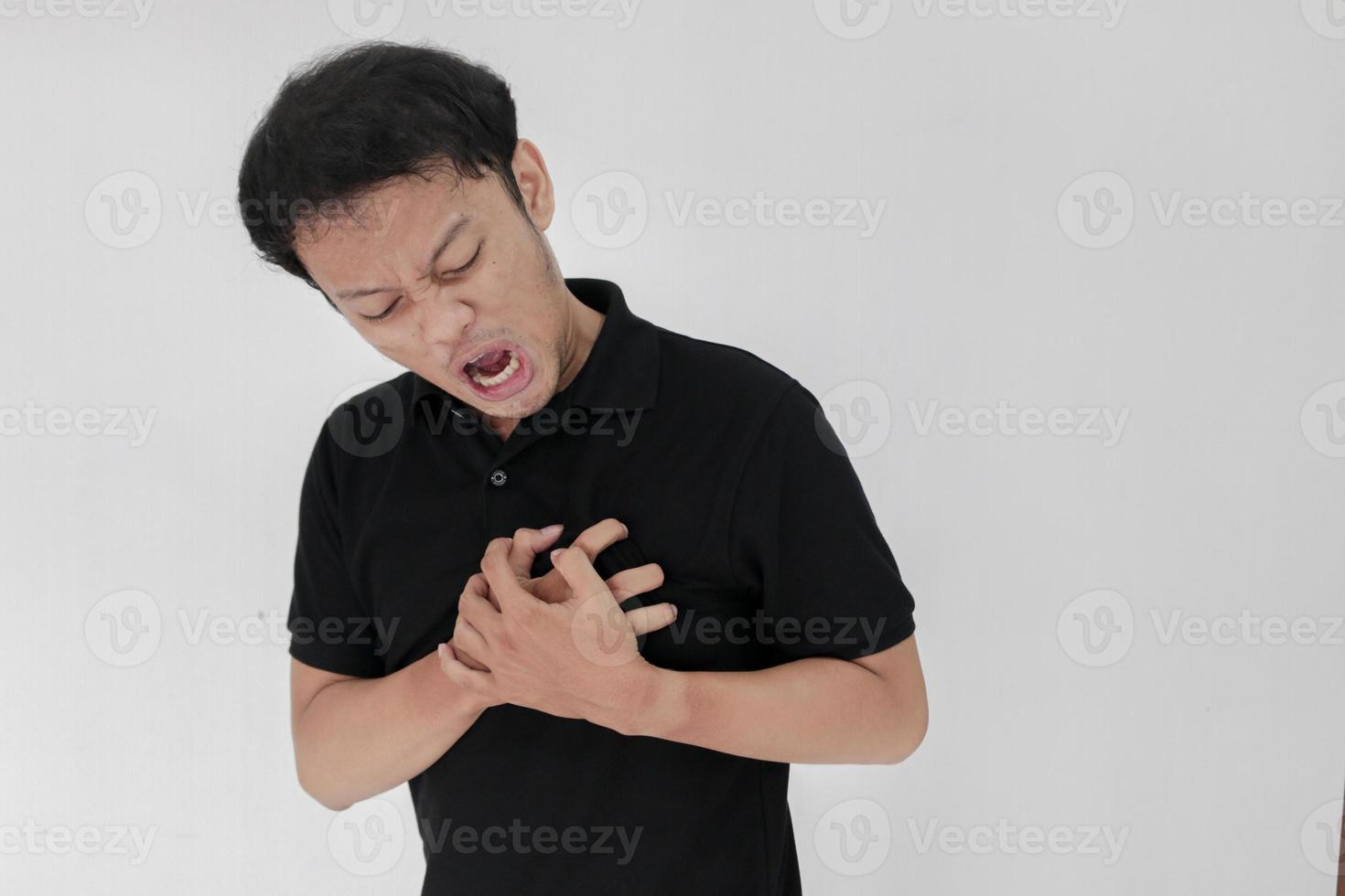 Heart attack or broken heart of young asian man with hurt emotion wear black shirt photo