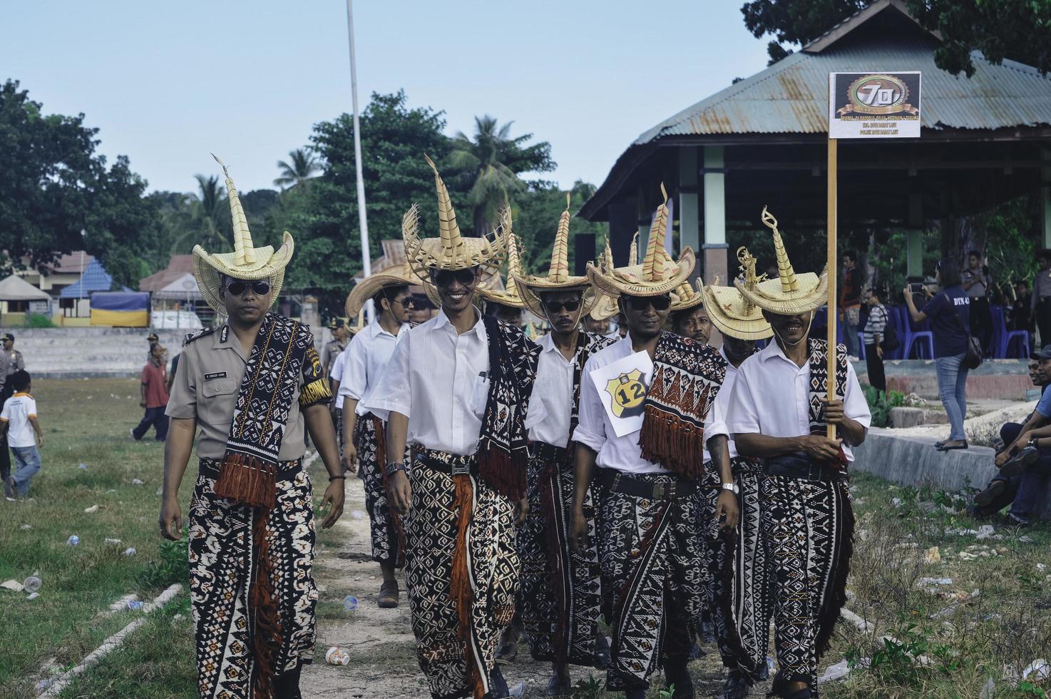 la gente de la isla de la memoria usa el tradicional sombrero de paja tradicional tilangga y la tela ikat de la memoria o la memoria kain tenun en el festival. memoria, indonesia - abril de 2020. foto