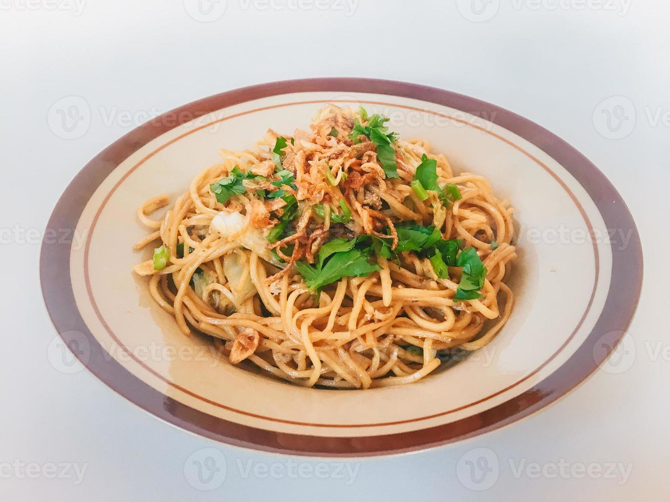 Mie Goreng Jawa or bakmi jawa or java noodle. Indonesian traditional street food noodles from central java or Yogyakarta, indonesia on white background. photo