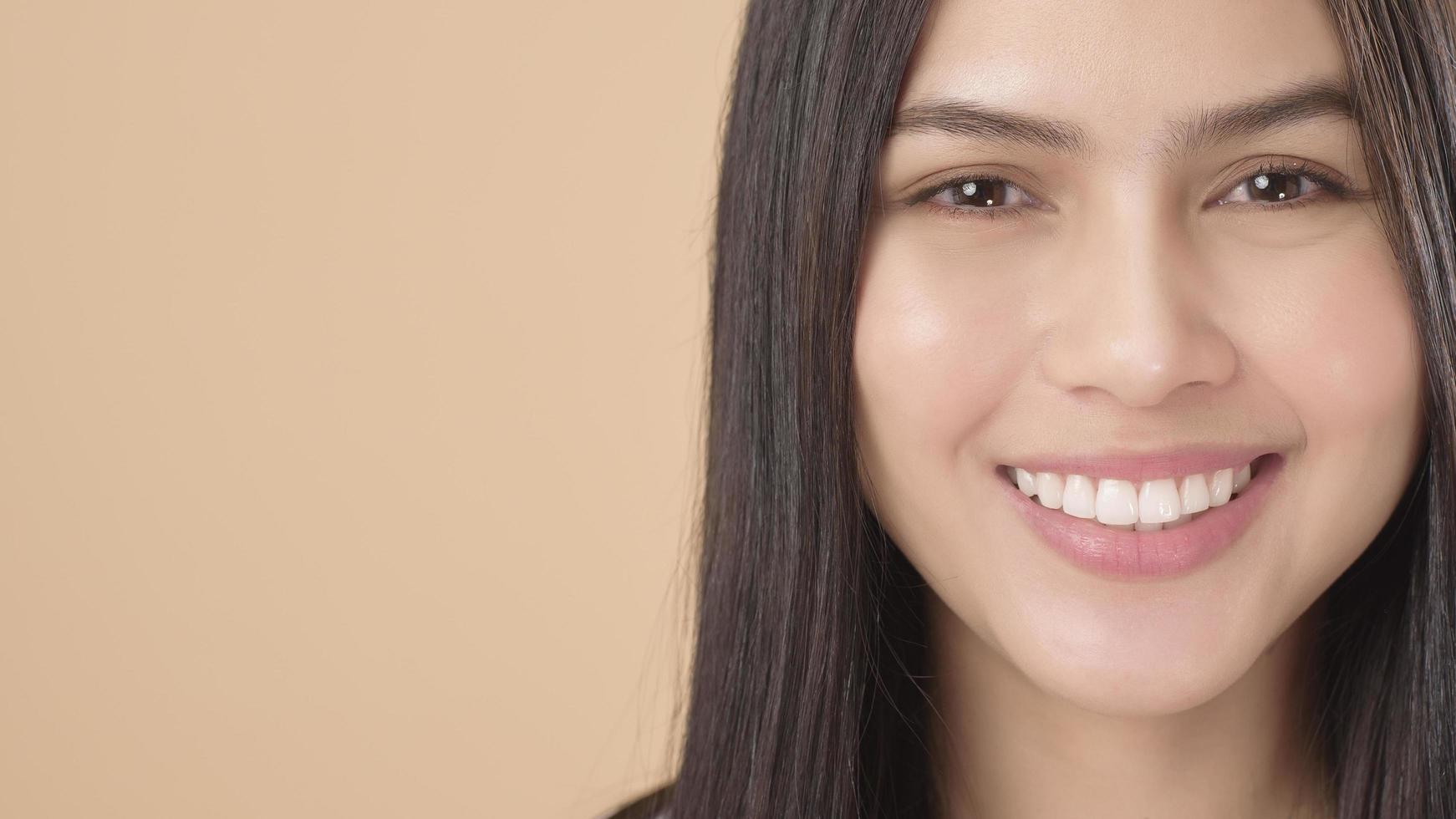 A Portrait of Asian woman with white T-shirt over Light brown background studio photo