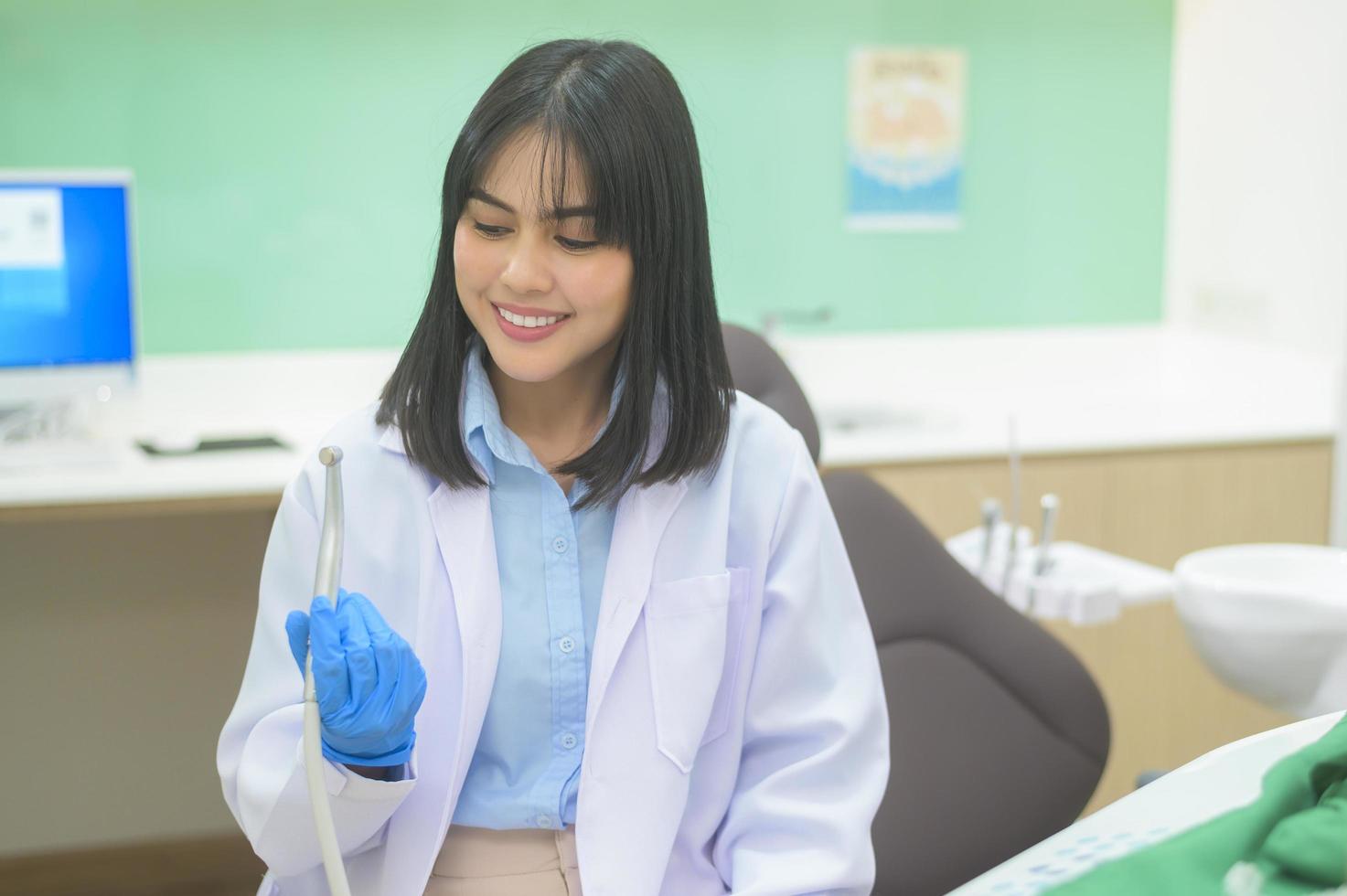 mujer dentista sosteniendo una sonda dental y un espejo revisando al paciente en la clínica dental, control de dientes y concepto de dientes sanos foto