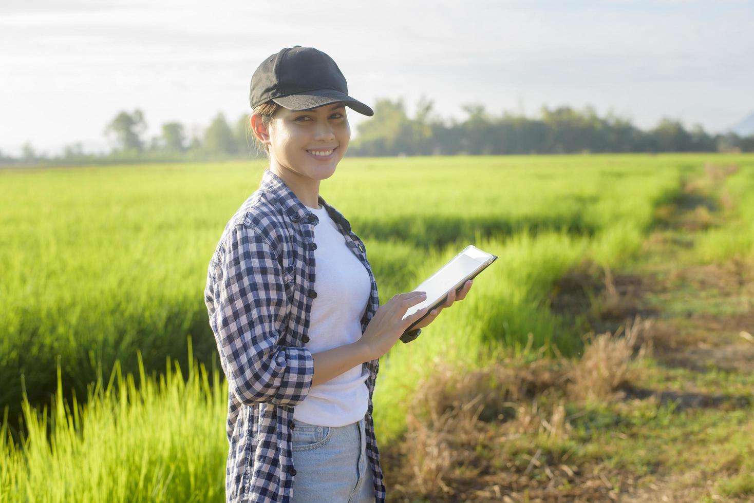 Young female smart farmer with tablet on field,High technology innovations and smart farming photo