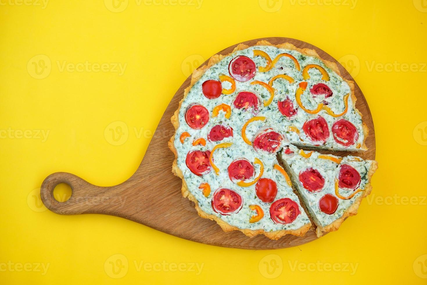 French quiche with tomatoes and pepper on yellow background photo