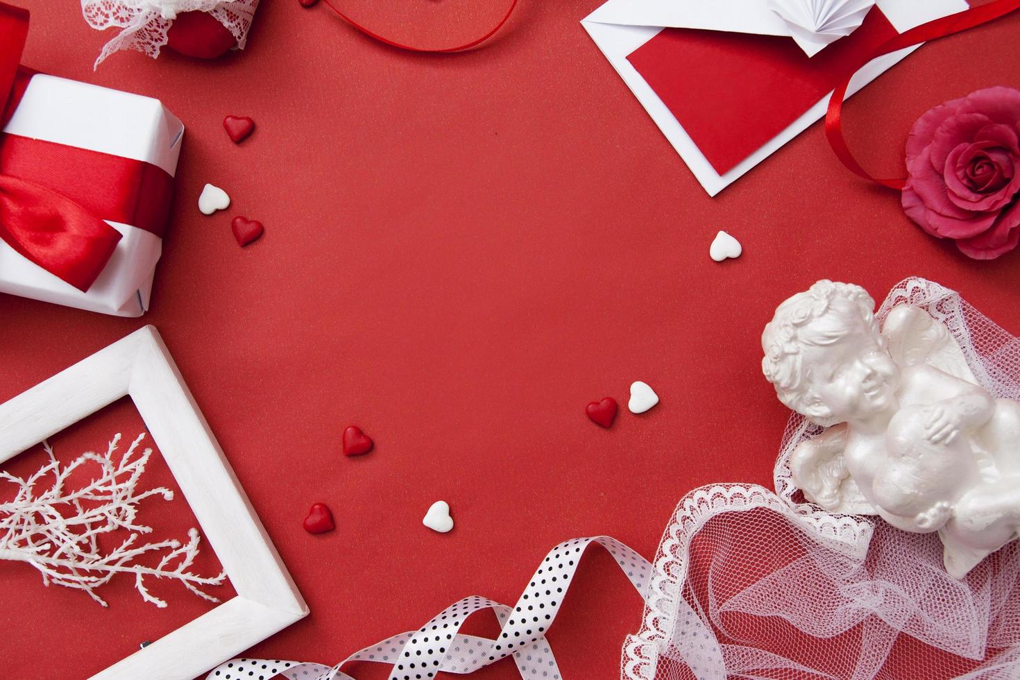 Envelope, gift, heart, rose, angel, ribbons for Valentines Day flat lay on red background with copy space photo