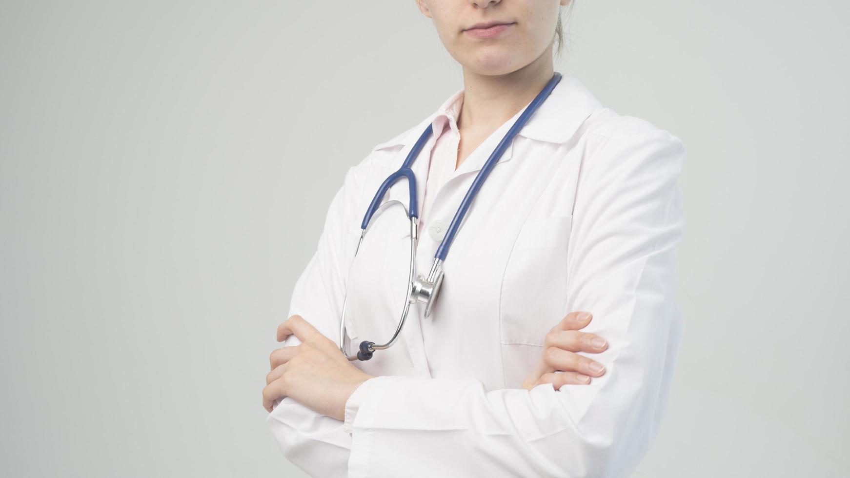 Portrait of an attractive young female doctor in white coat. photo