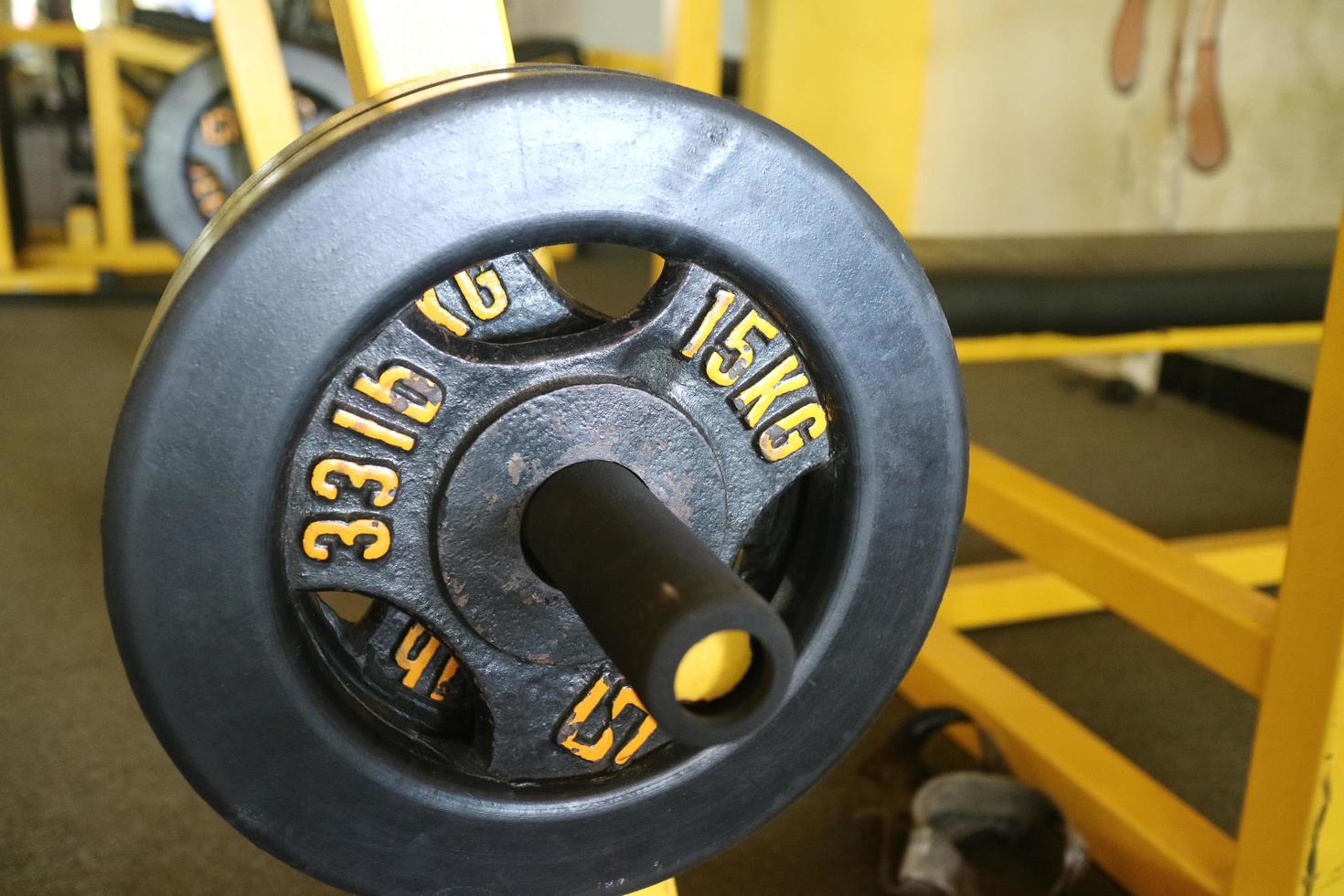 Editorial image of a 15 KG black barbell plate for exercising in the gym photo