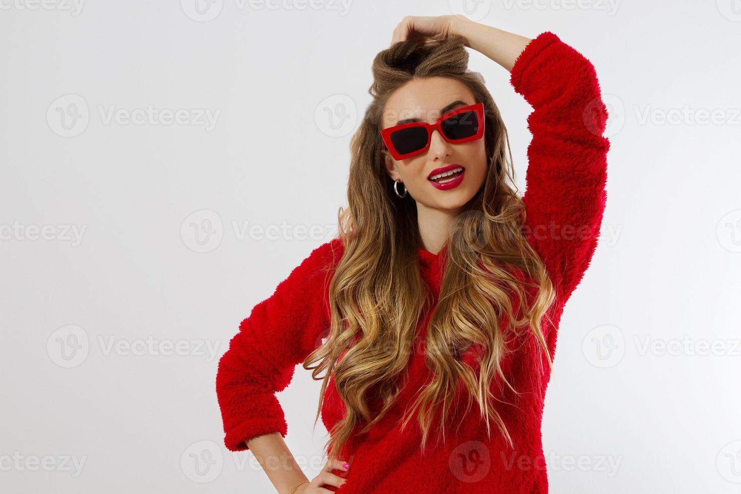 Happy, shock, excited woman face closeup. Girl in bright red hoodie autumn clothes red sunglasses isolated. white background, copy space. Beautiful female surprised, cheerful. model Fun time photo