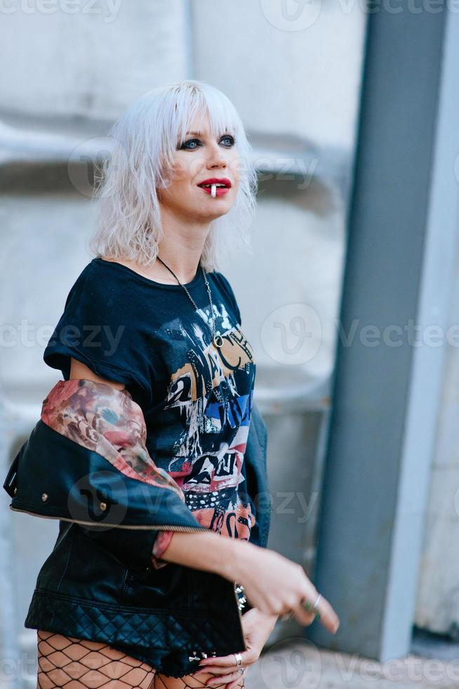 retrato de una elegante mujer joven rubia grunge con maquillaje para fumar cigarrillos foto