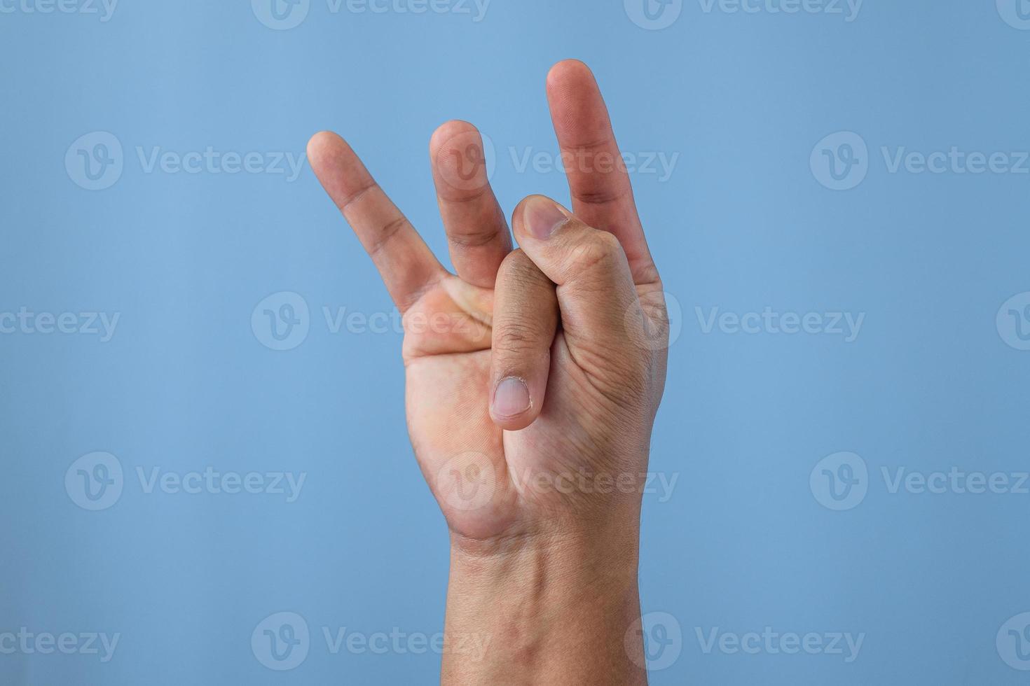 Office syndrome concept. Middle finger is stretched after working. Close up shot isolates on blue background. Forehand view. photo
