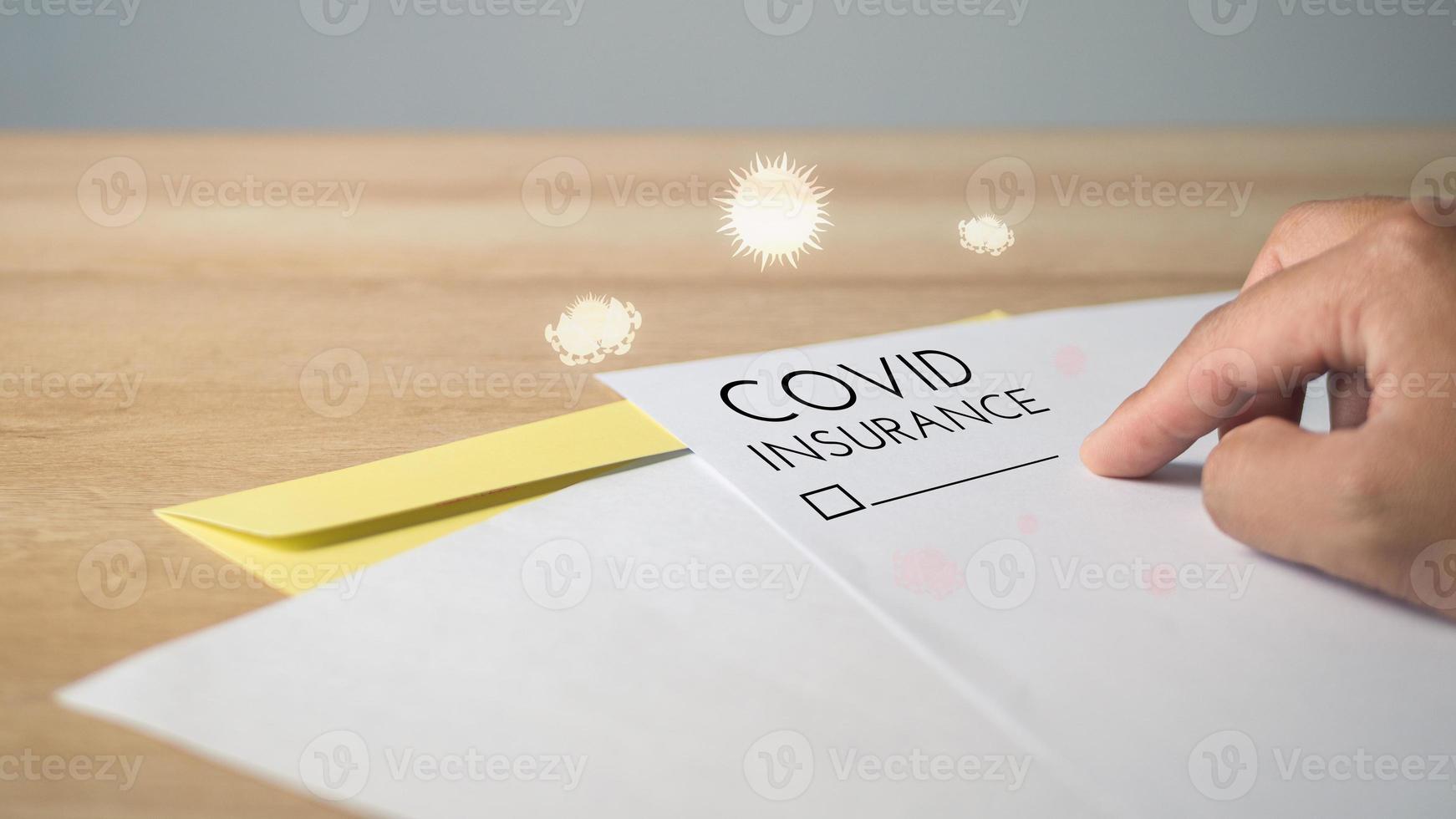 Covid insurance form with overlay coronavirus graphics. There is a blank for confirmation of signature. Papers on the table. photo