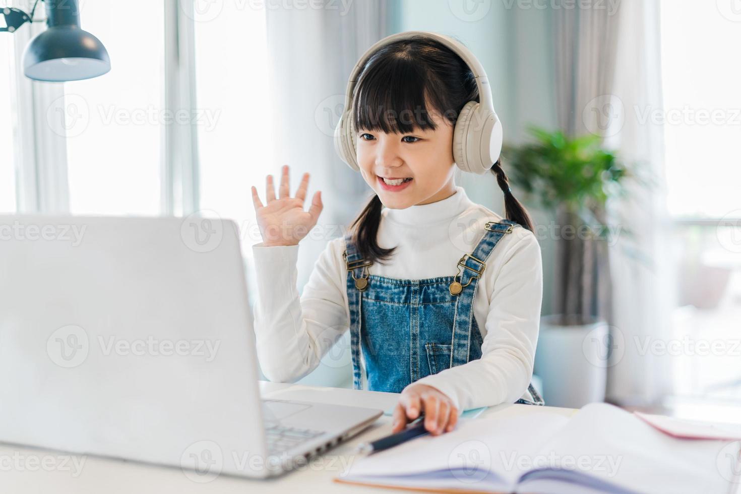 retrato de una niña que estudia en línea en casa foto
