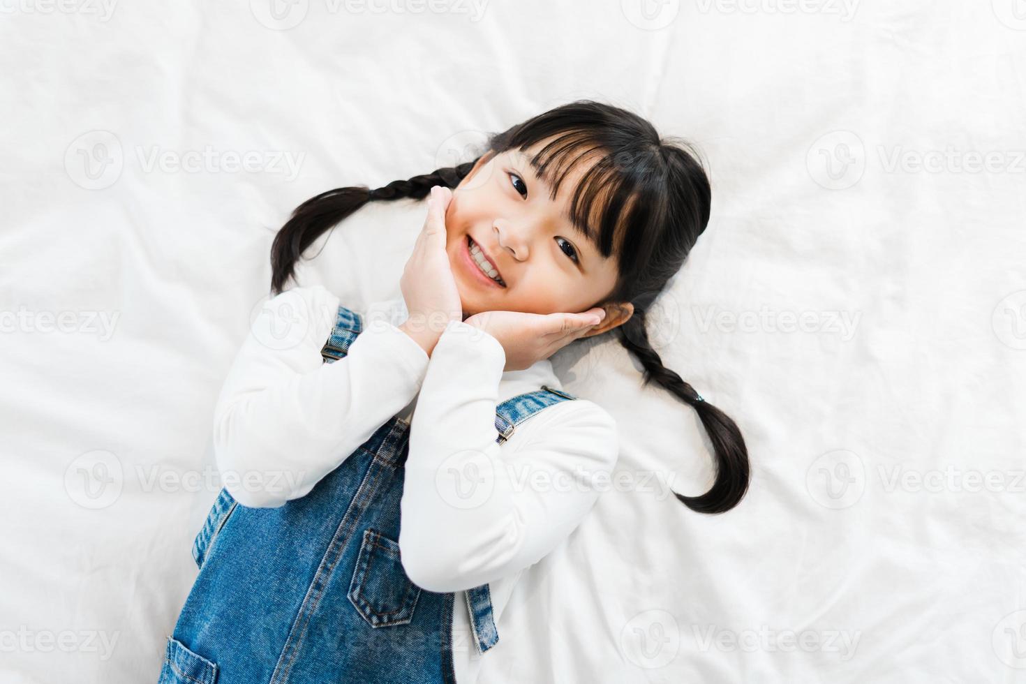 retrato de niña acostada en la cama foto