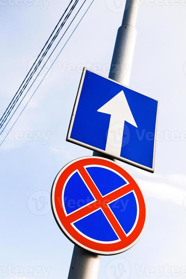 Red and blue road sign view against the sky photo