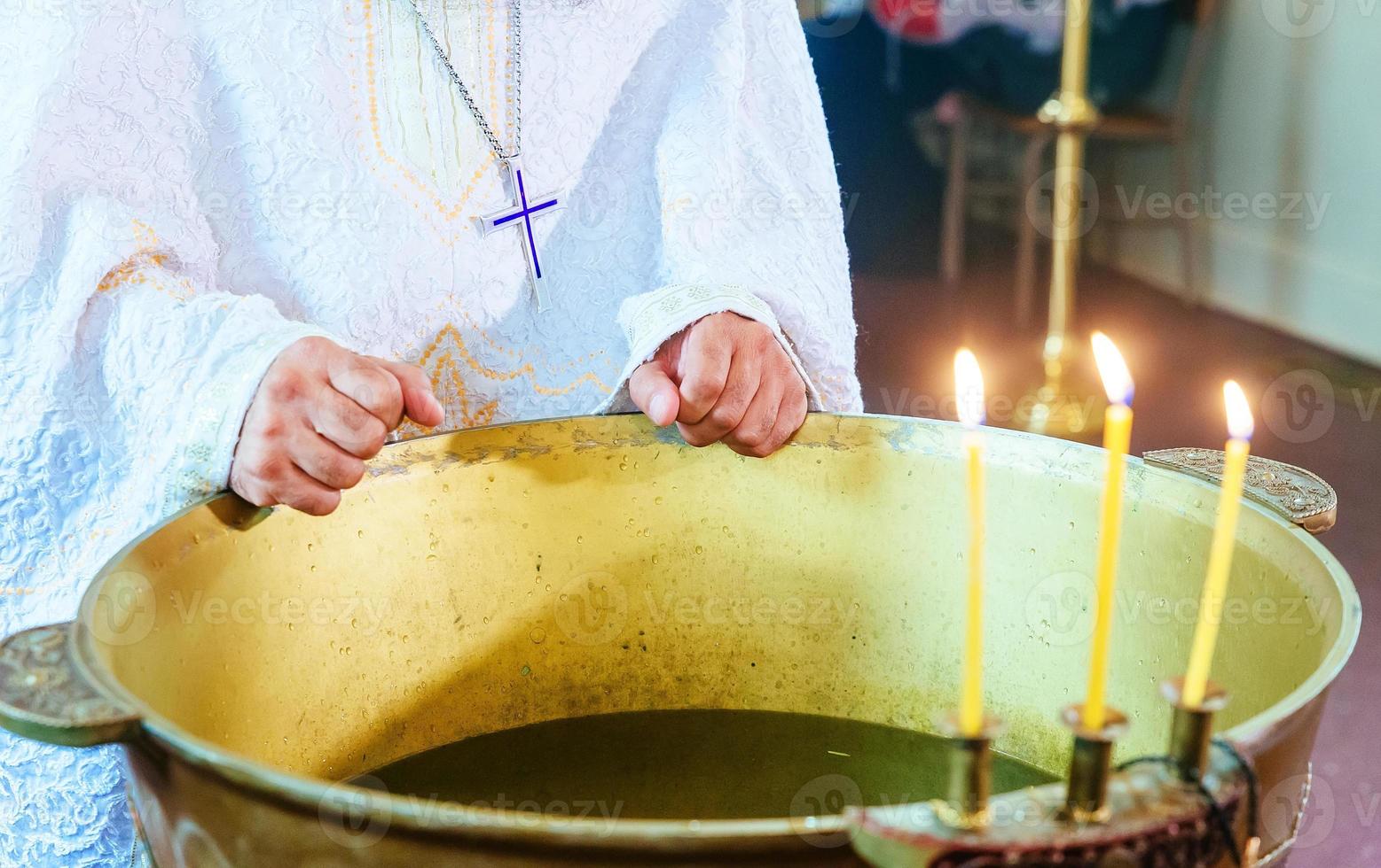 the baptism of the Orthodox Christians, the cross is lowered into the water photo