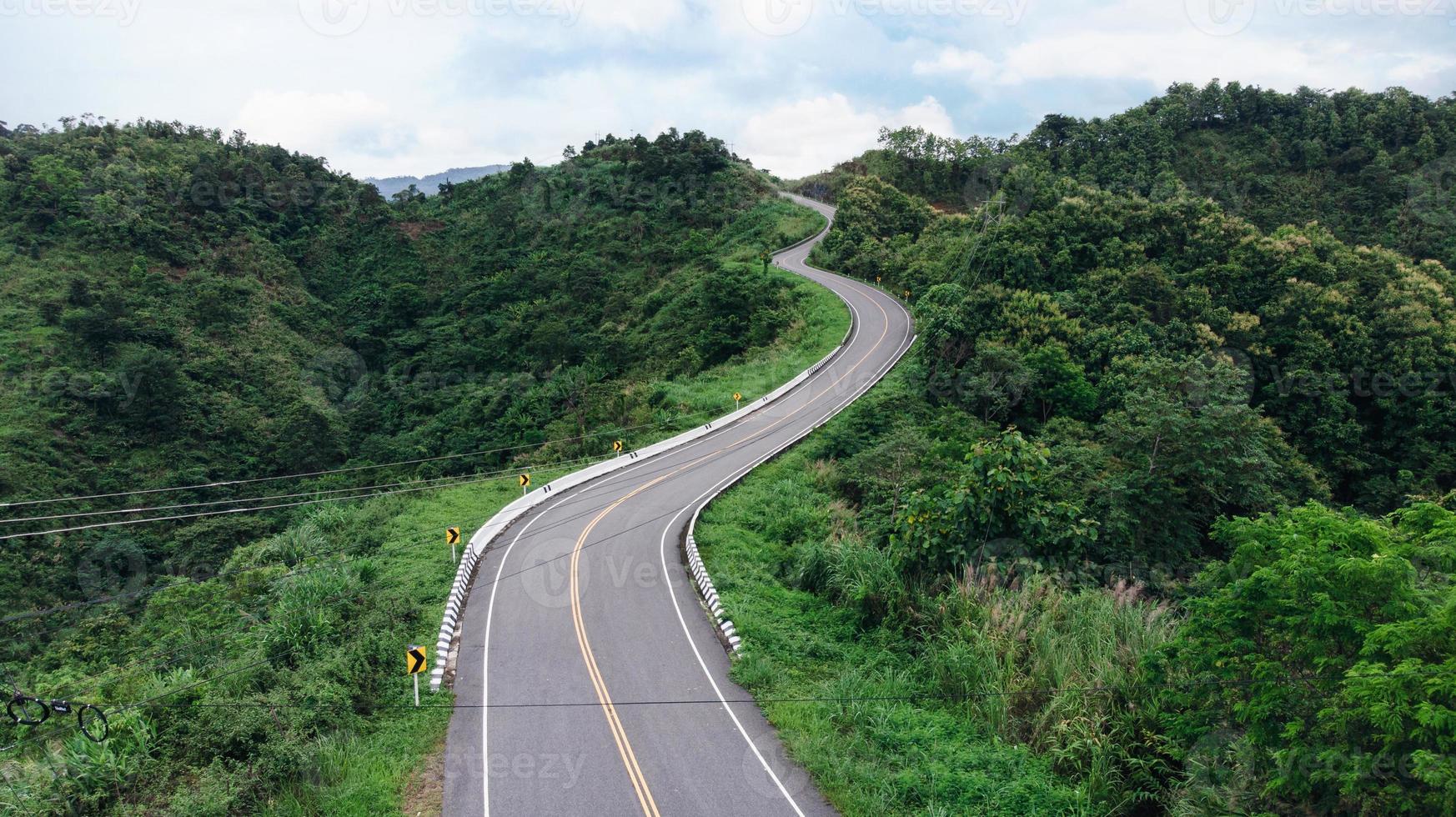 Aerial view of winding road shaped like 3 on top of mountain in tropical rainforest at Nan province photo