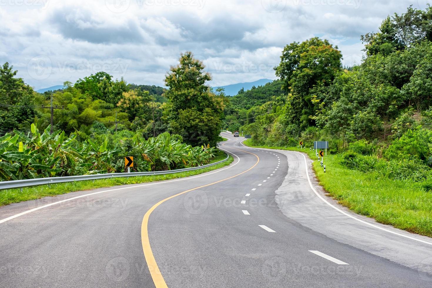 carretera de asfalto curvada con camión en la colina foto