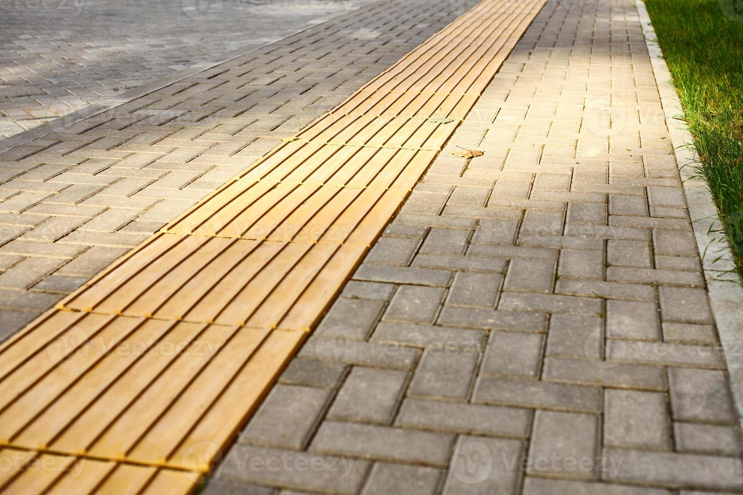 Yellow tactile paving on walkway, tactile ground surface indicators for blind and visually impaired photo