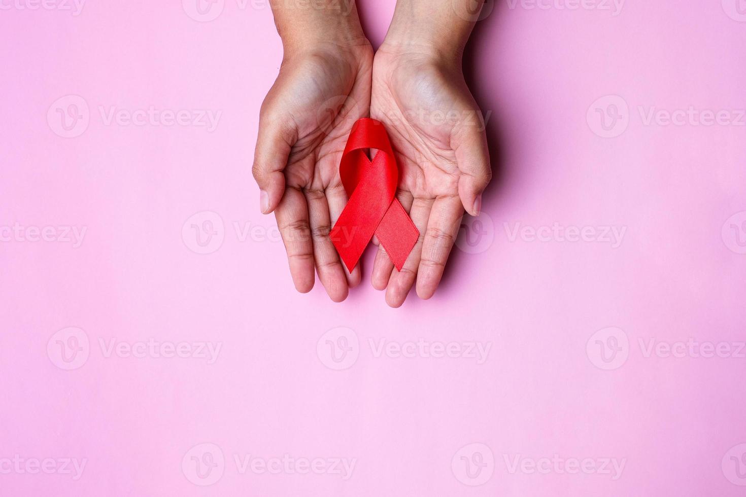 Hands holding red ribbon, hiv awareness concept photo
