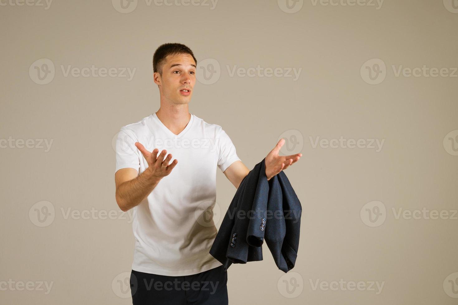 man in a white T-shirt gestures against the background photo