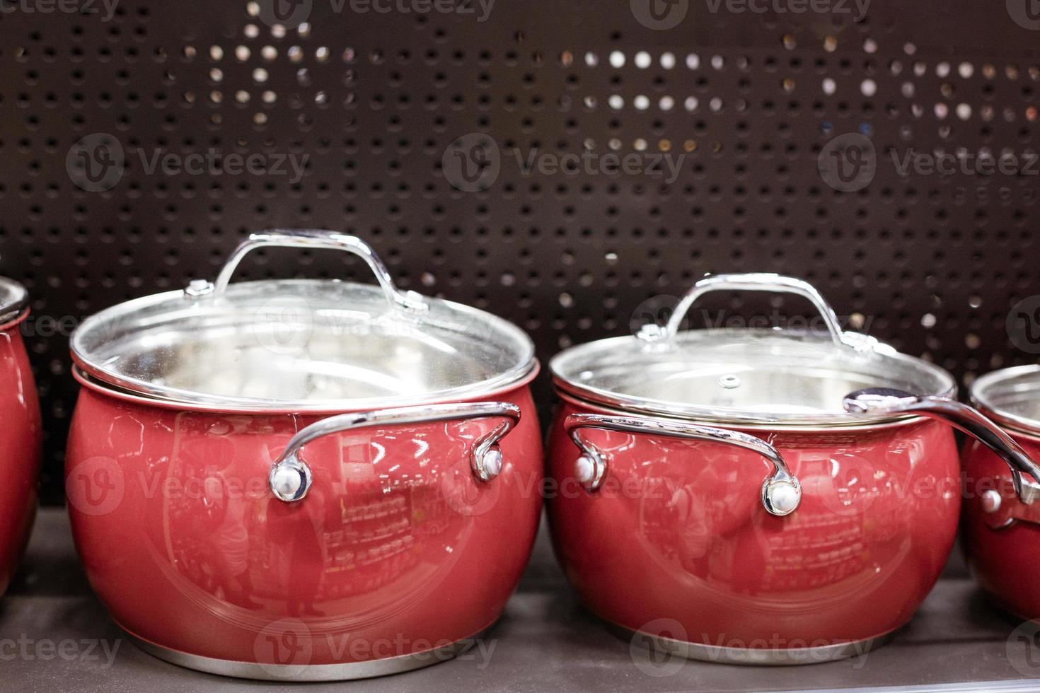 Beautiful red new pans stand on a shelf in a store photo