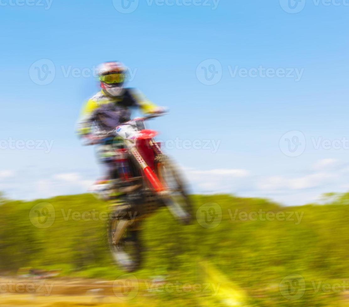 The blurry image of motorcycle rider during motocross race photo