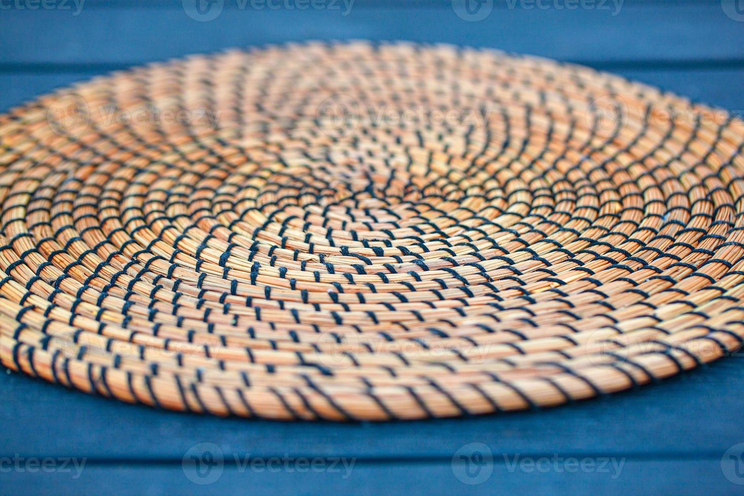 Wicker plate holde on table. Details of wicker plate. Selective focus photo
