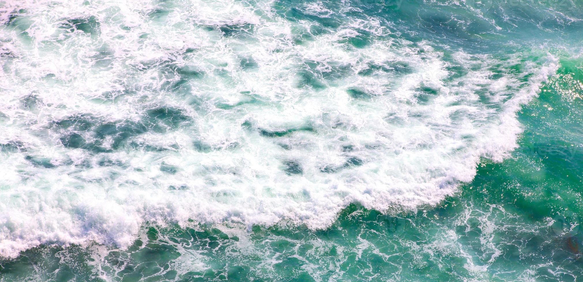 scenic aerial shot of blue ocean with foamy waves for background photo