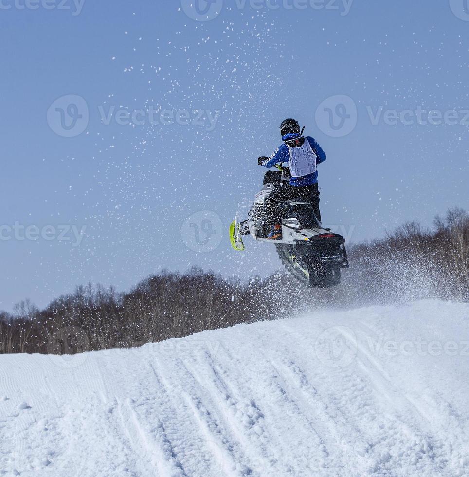 Snowmobile in high jump above track. photo