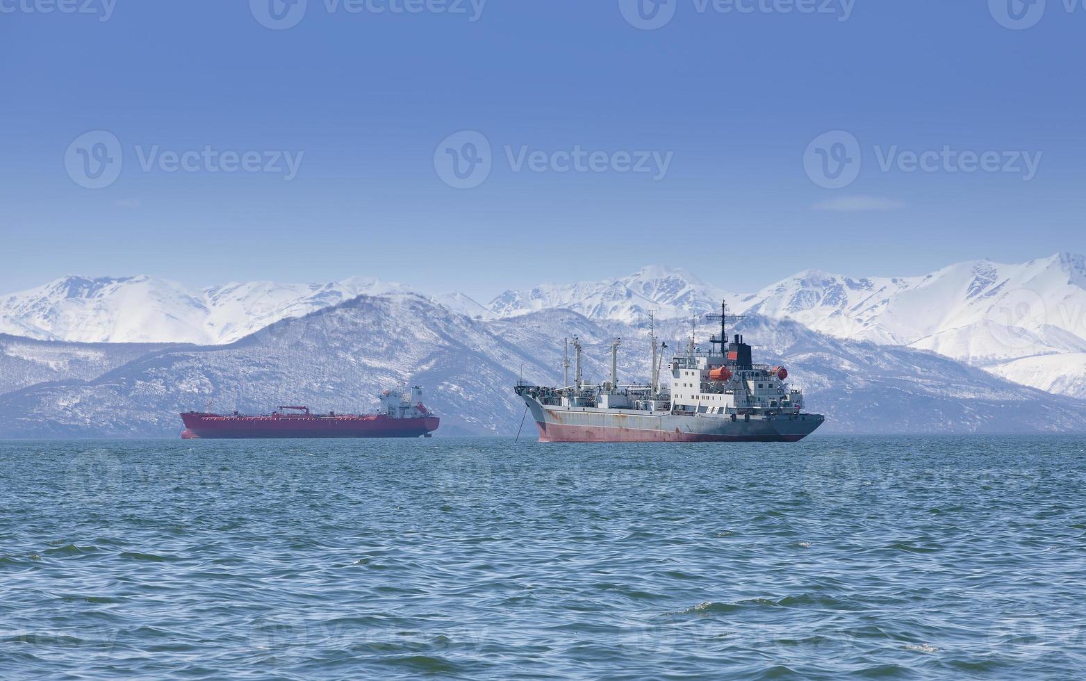 The large fishing vessel on the background of hills and volcanoes photo