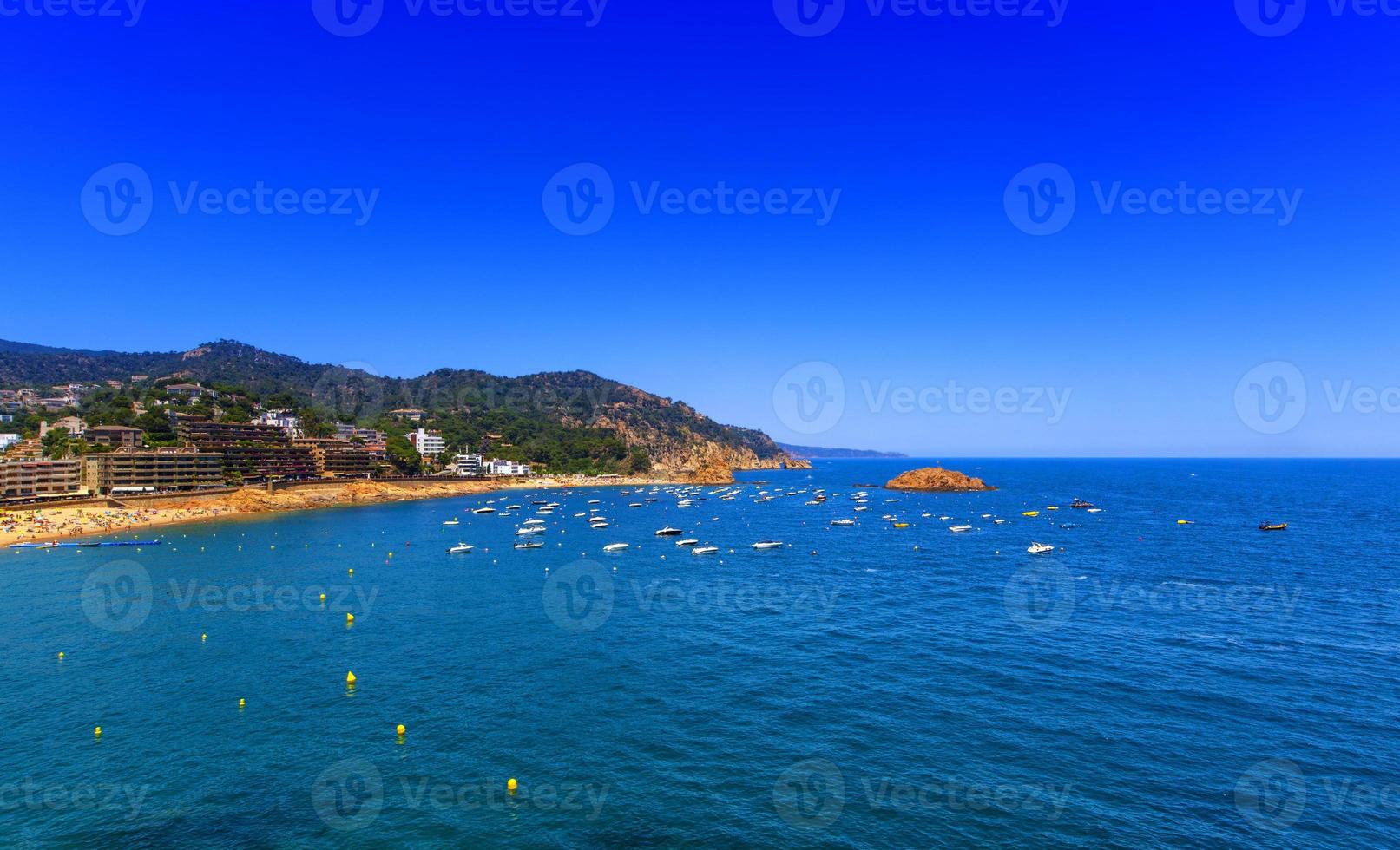 view from the shore to the sea and boats photo