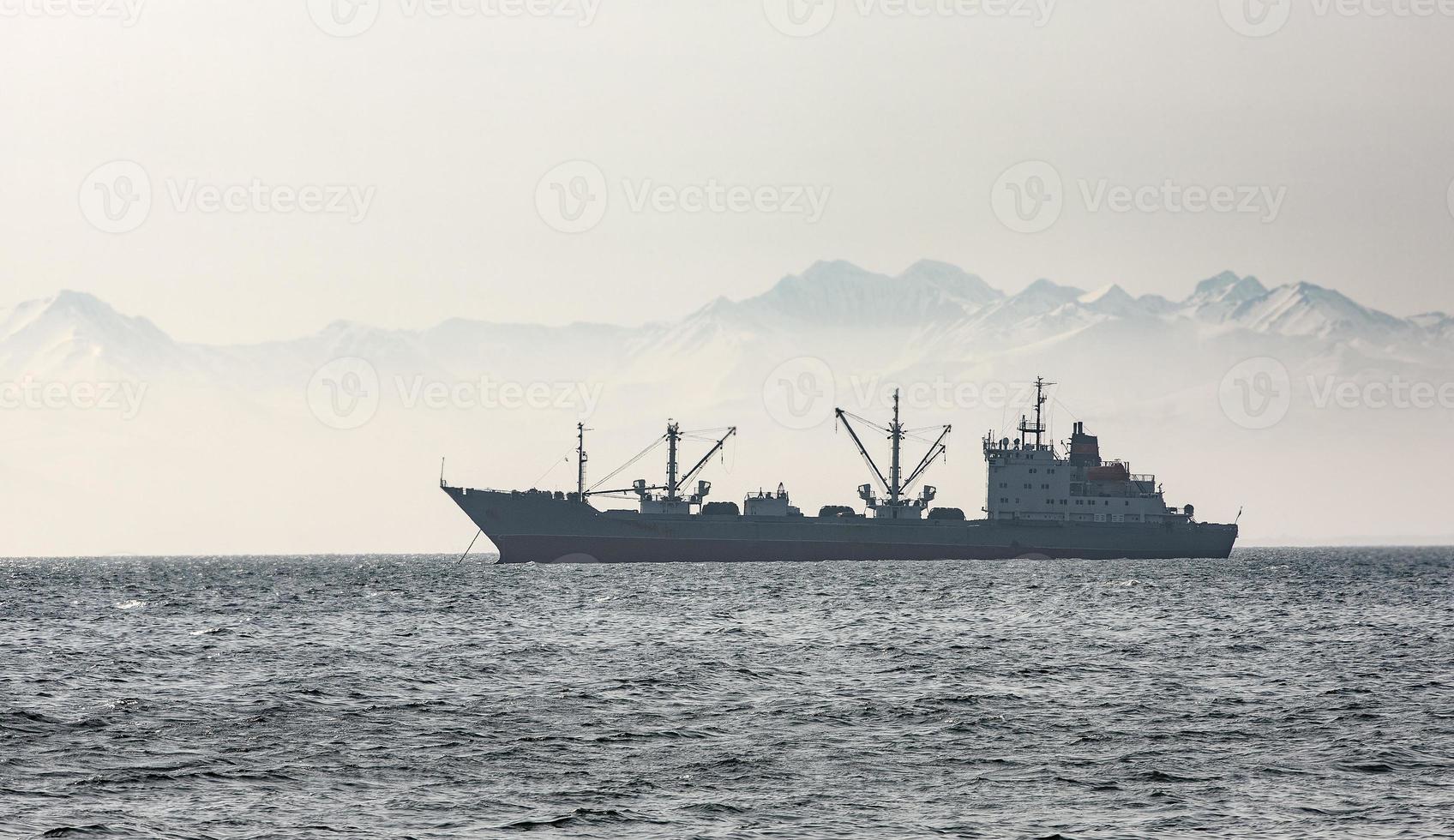 el gran barco pesquero en el fondo de colinas y volcanes foto