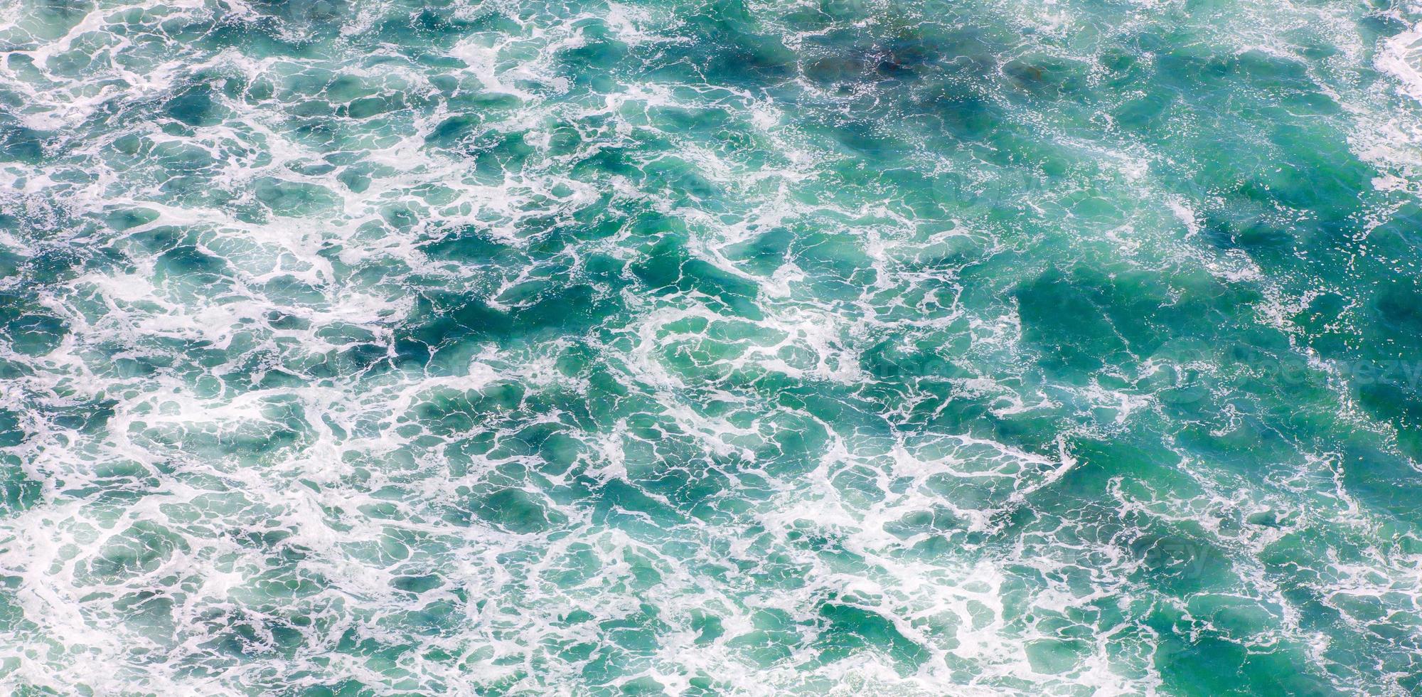 scenic aerial shot of blue ocean with foamy waves for background photo