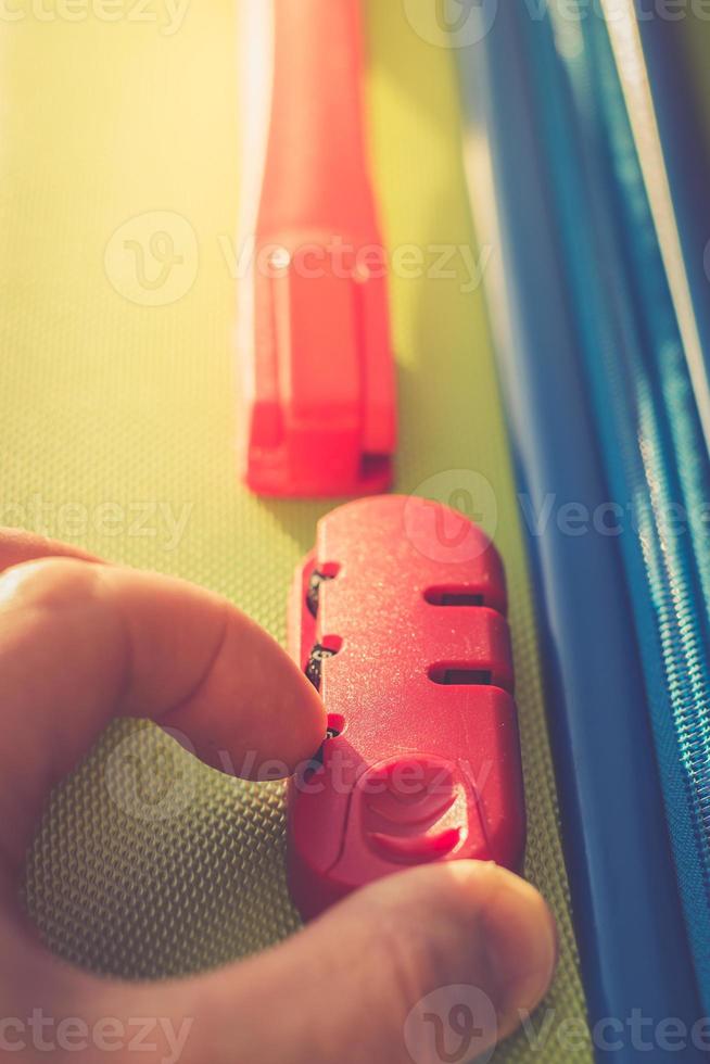 person enters code on the locking mechanism on the suitcase 5738135